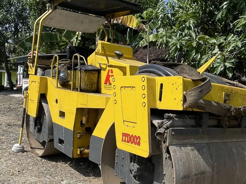 Roller kuning dengan drum besar di atas kerikil