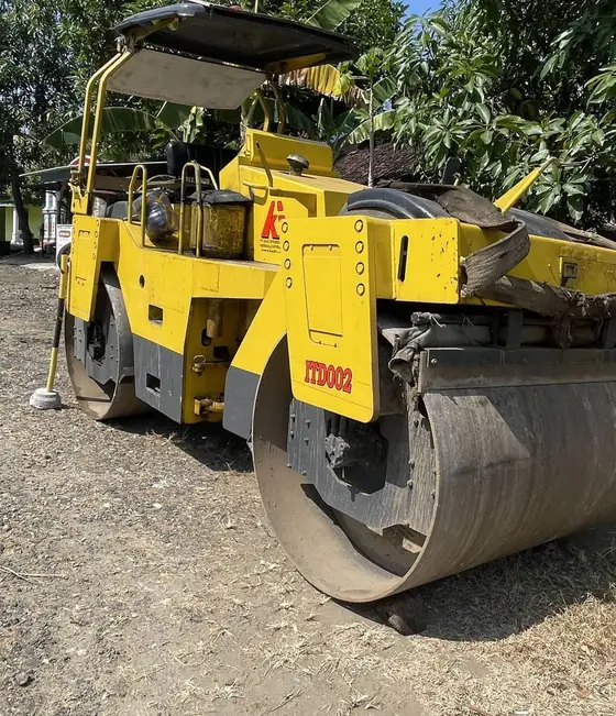 Roller kuning dengan drum besar di atas kerikil