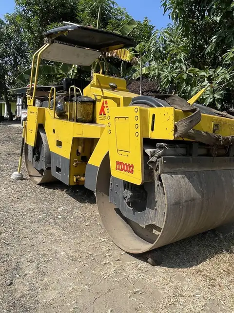 Roller kuning dengan drum besar di atas kerikil