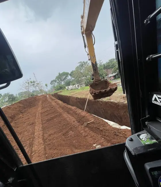 Pemandangan dari kabin ekskavator ke tanah merah yang baru dikeruk