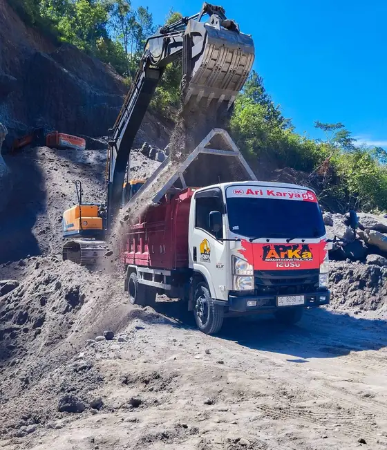 Ekskavator mengisi bak dump truk ARKA dengan tanah berpasir